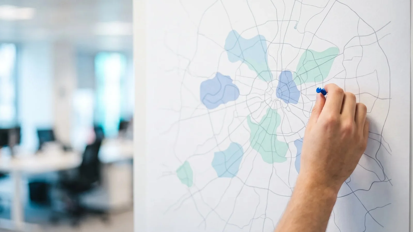 Mão colocando um alfinete azul em um mapa de uma região metropolitana