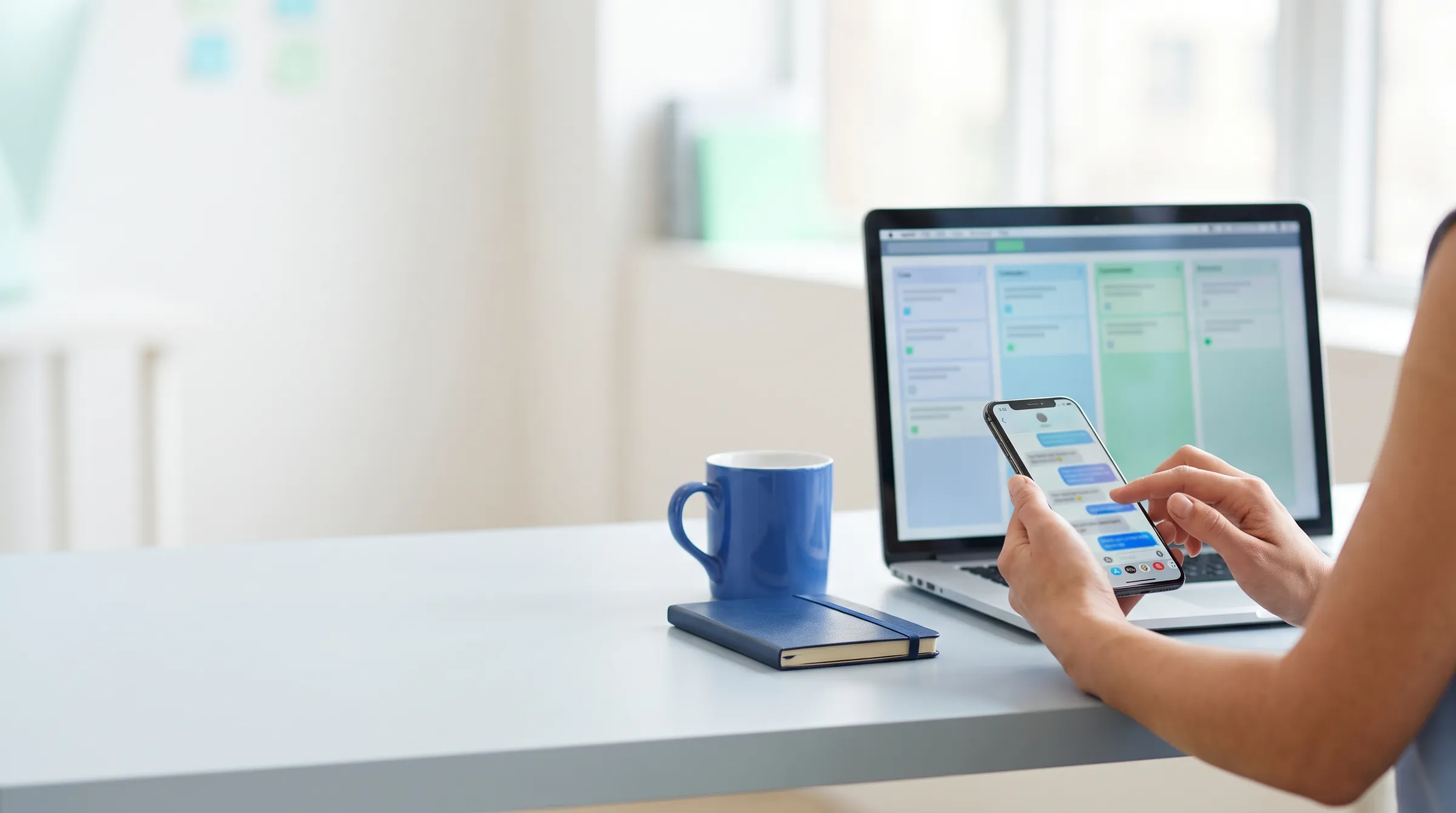 Pessoa respondendo mensagens no celular ao lado de um notebook com um funil de vendas