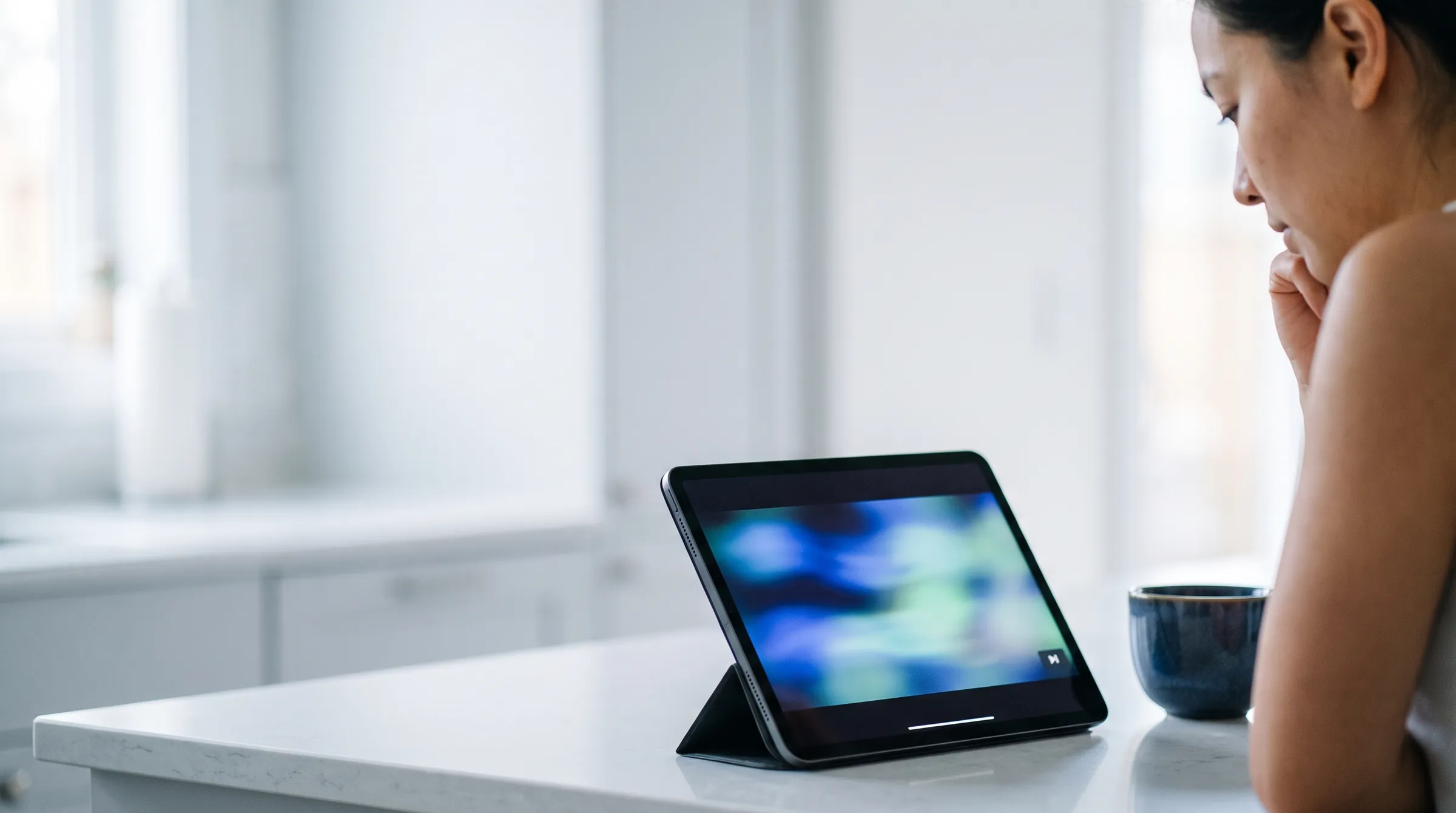 Pessoa assistindo a um vídeo em um tablet sobre a bancada